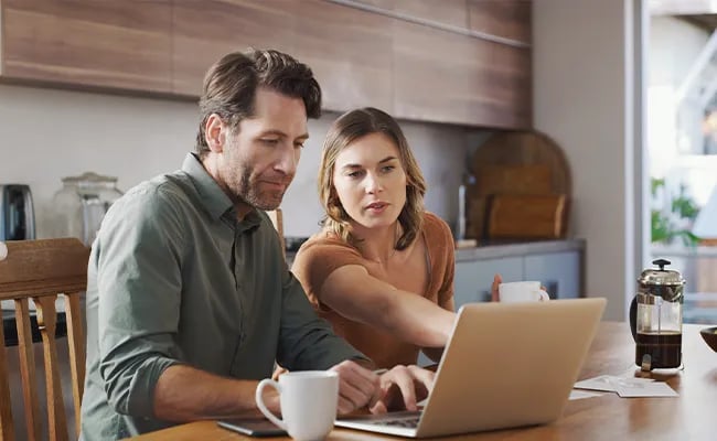 Couple at kitchen table pointing